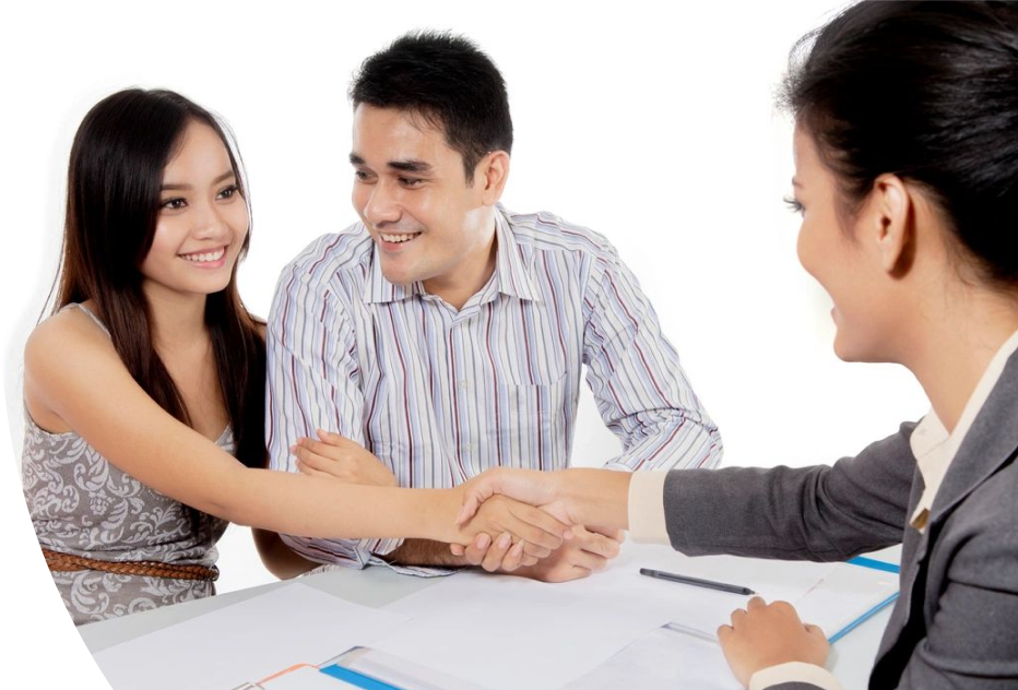 A man and woman shaking hands over a table.